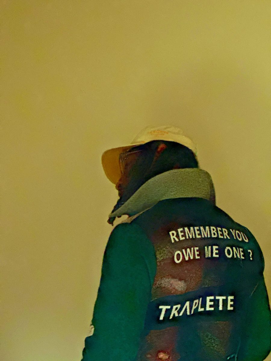 Back view of the TRAPLETE vest in warm yellow light, face hidden